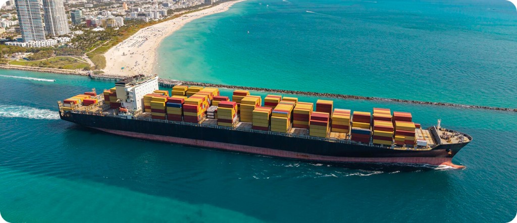 Container ship at sea with coastal skyline